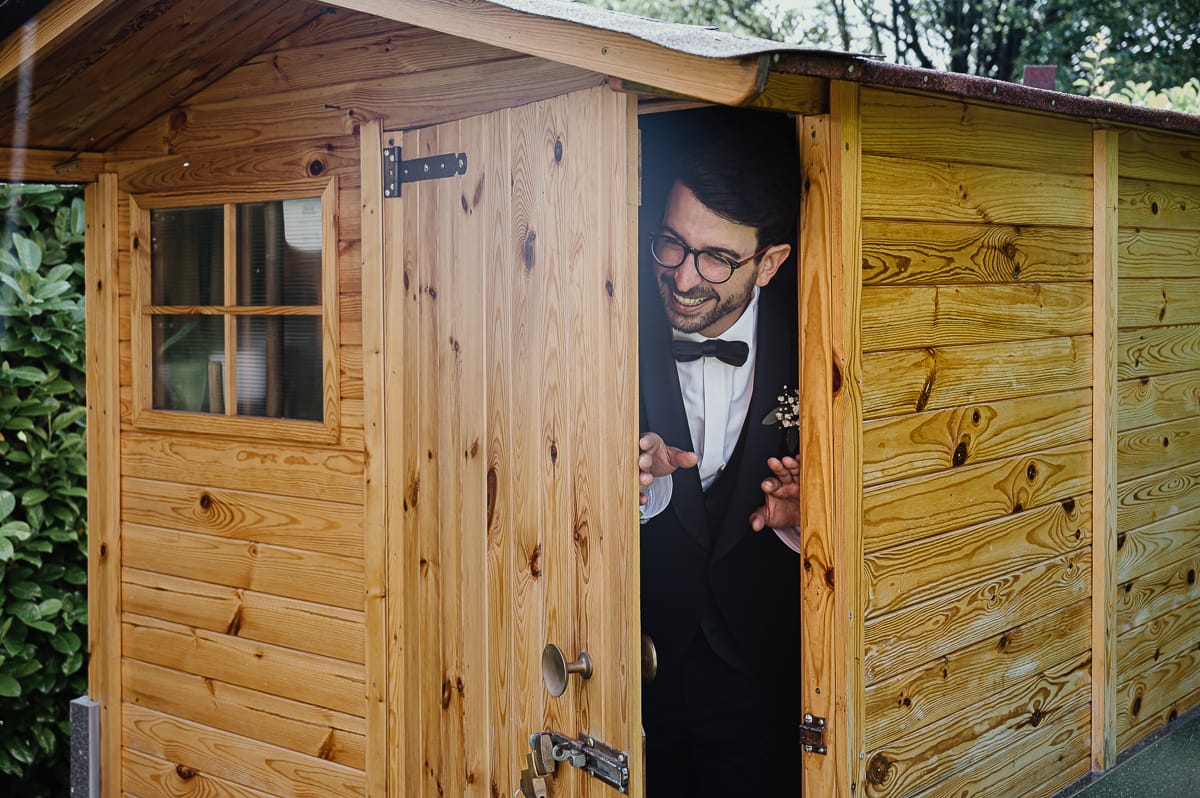 preparazione dello sposo a Chieri. Sposo fa capolino dalla casetta di legno del giardino.