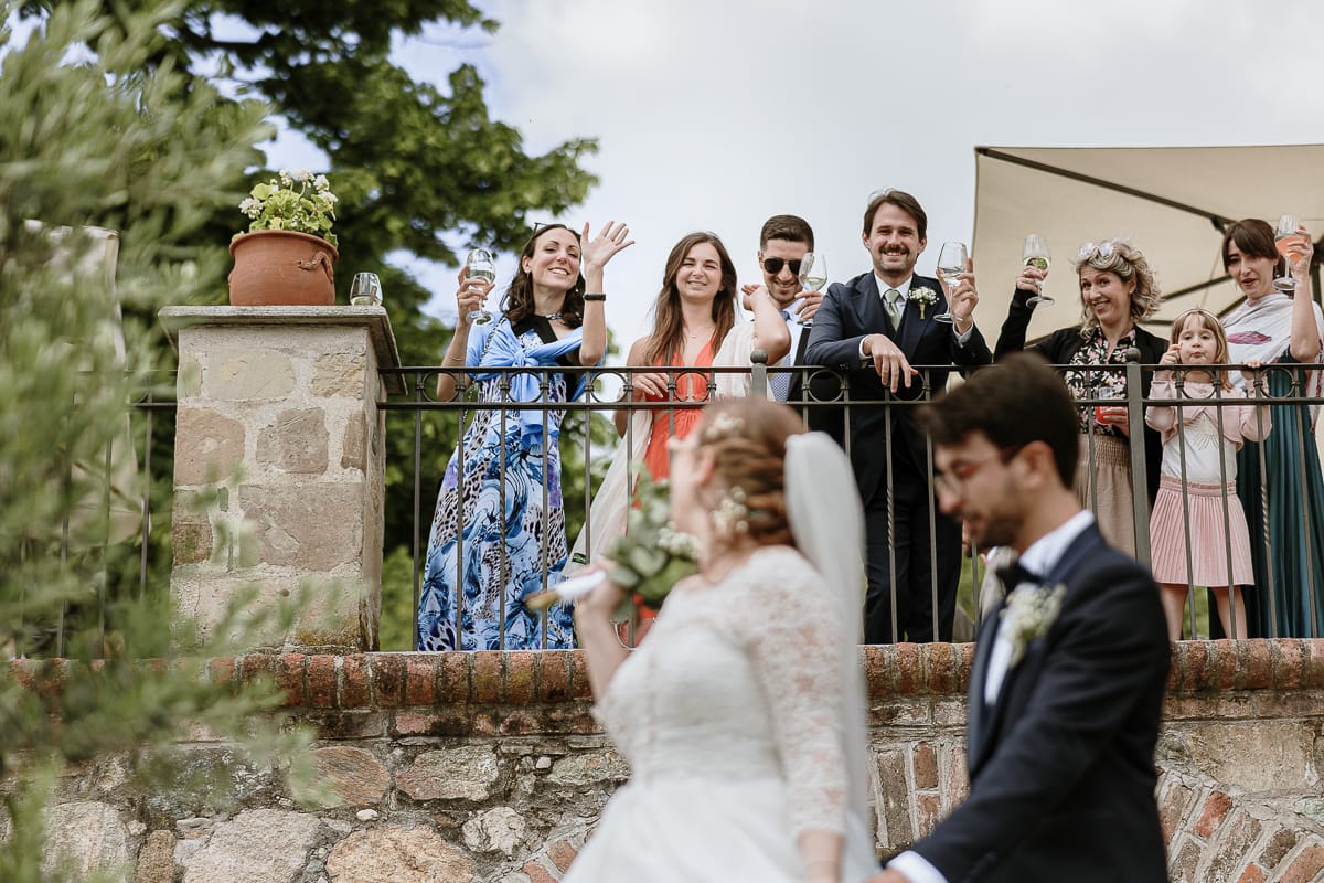 Matrimonio a Villa Ala di Rivalba (TO). Sposi salutano gli amici che stanno già facendo l'aperitivo mentre si avviano per il servizio fotografico di coppia.
