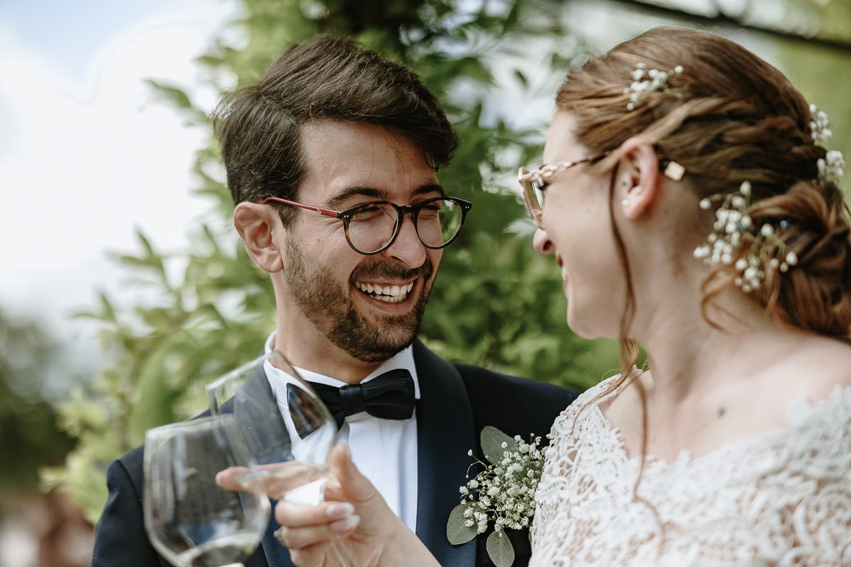 Fotografo matrimonio Torino. Momento aperitivo a Villa Ala. Sposi brindano sorridendo reciprocamente.