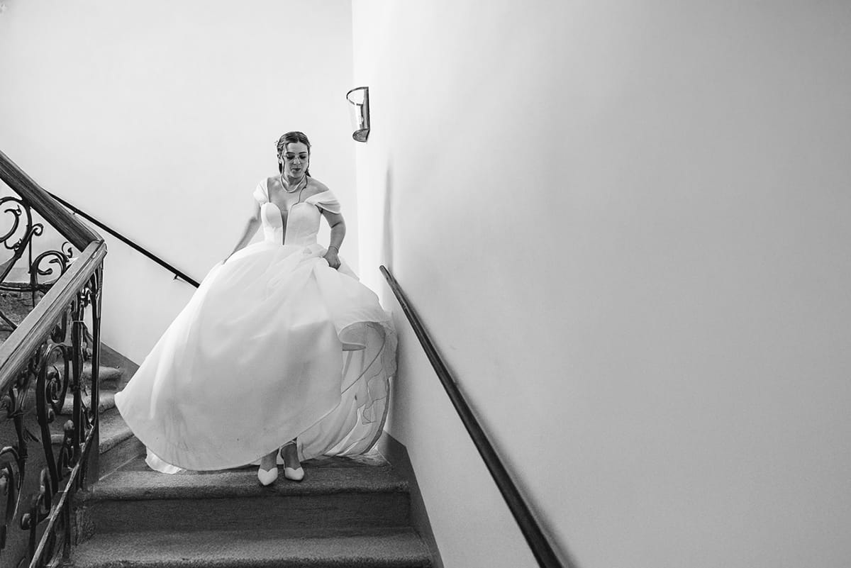 Fotografo matrimonio Torino. La sposa scende lo scalone di Villa Ala. Bianco e nero.