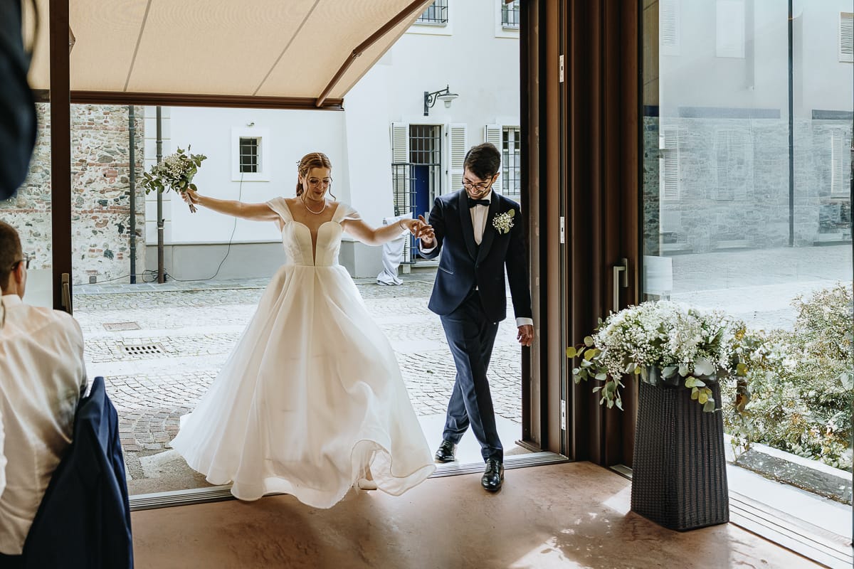 Fotografo matrimonio Torino. Gli sposi entrano nella veranda di Villa Ala dove si terrà il ricevimento.