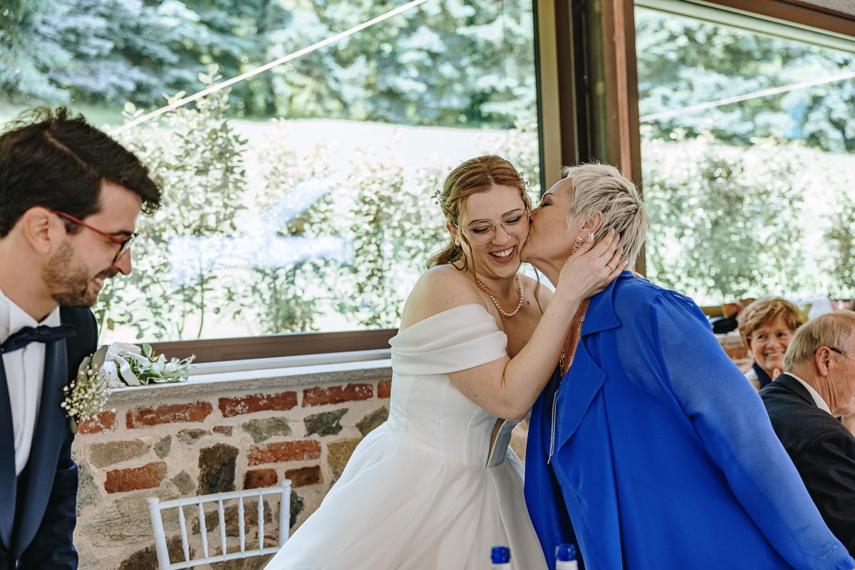 Fotografo matrimonio Torino. Pranzo nuziale a Villa Ala. mamma bacia la sposa.