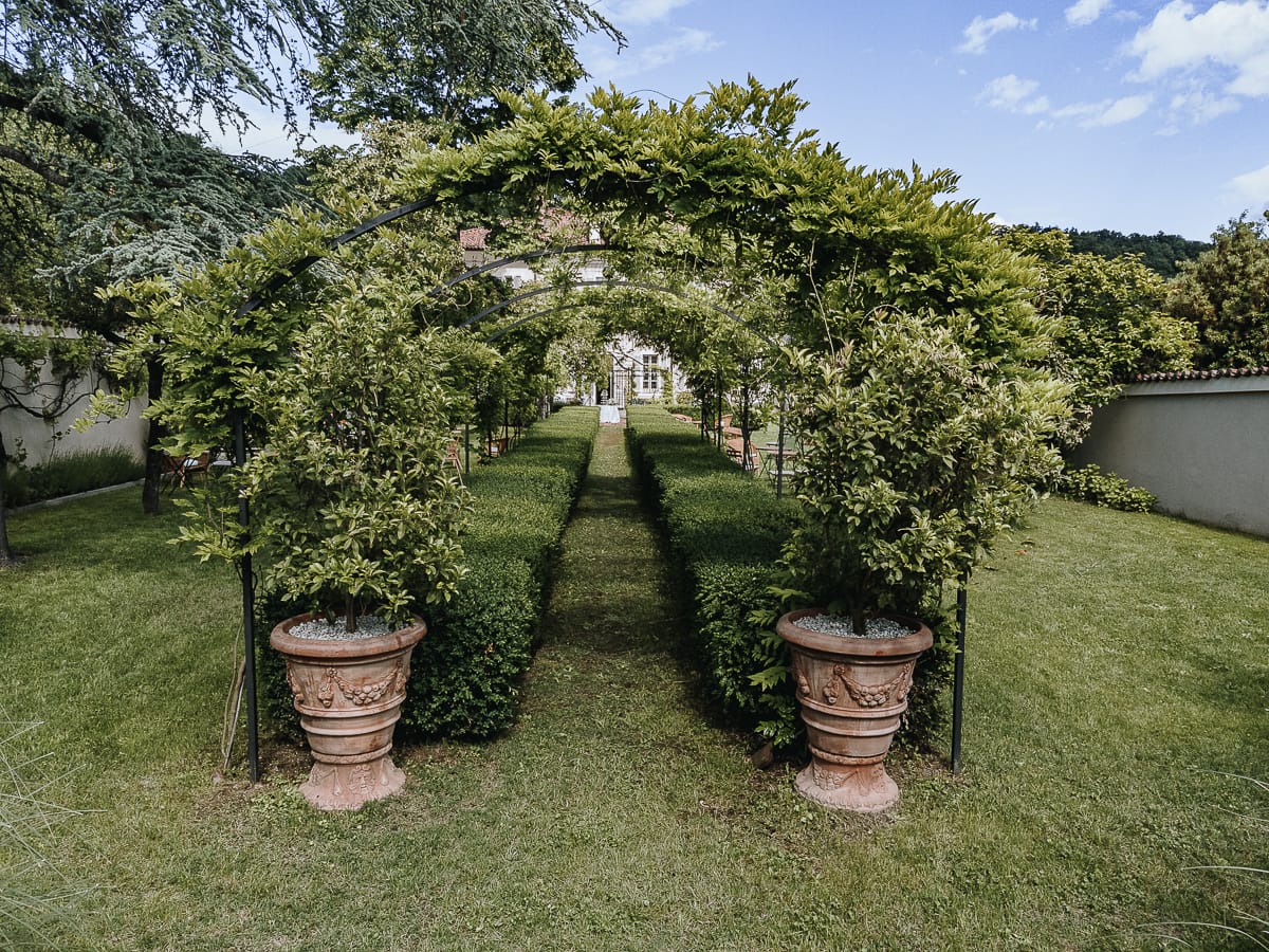 Fotografo matrimonio Torino. Corridoio con archi e rampicanti in uno dei giardini di Villa Ala.
