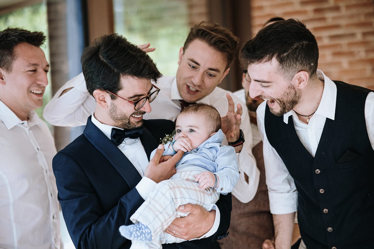 Fotografo matrimonio Torino. Pranzo nuziale a Villa Ala. Sposo con un neonato e con gli amici.