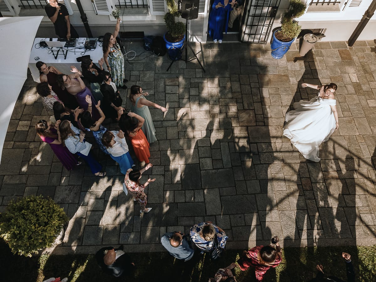 Fotografo matrimonio Torino. La sposa lancia il bouquet nel giardino di Villa Ala. Una ragazza lo prende con un'acrobazia. Foto dal drone