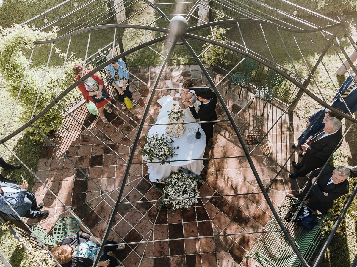 Fotografo matrimonio Torino. Taglio della torta sotto un gazebo nel giardino di Villa Ala. Foto aerea dal drone.