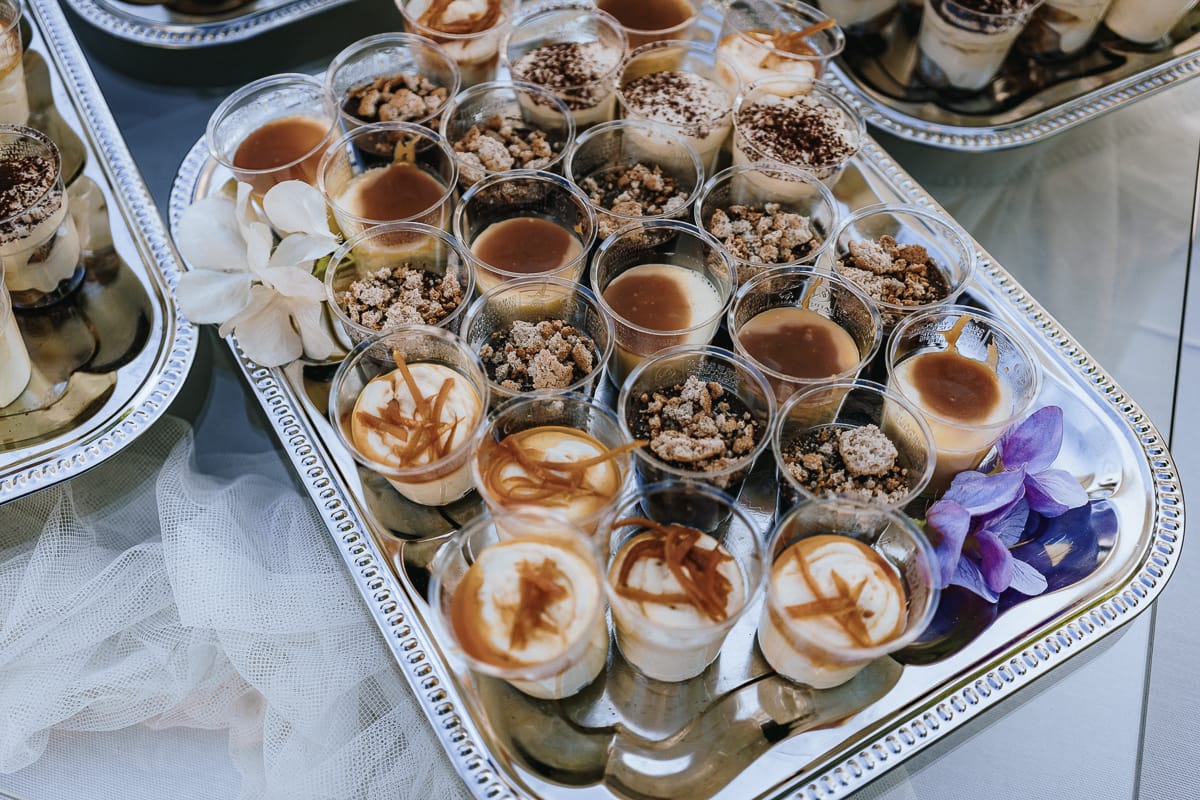 Fotografo matrimonio Torino. Taglio della torta sotto un gazebo nel giardino di Villa Ala. Tavolo dei dolci.