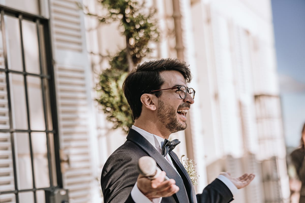 Fotografo matrimonio Torino. Lo sposo sorride dopo aver fatto il suo discorso nel patio di Villa Ala.