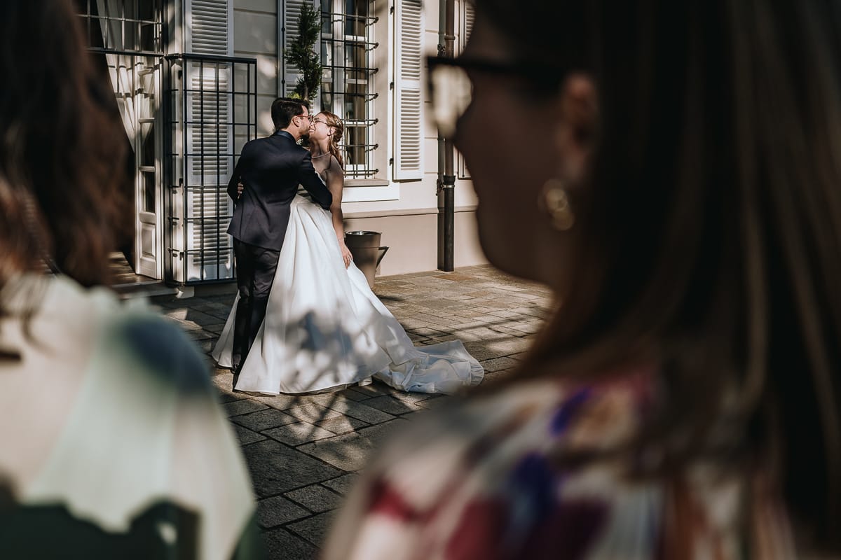 Fotografo matrimonio Torino. Gli sposi si baciano sul patio di Villa Ala.
