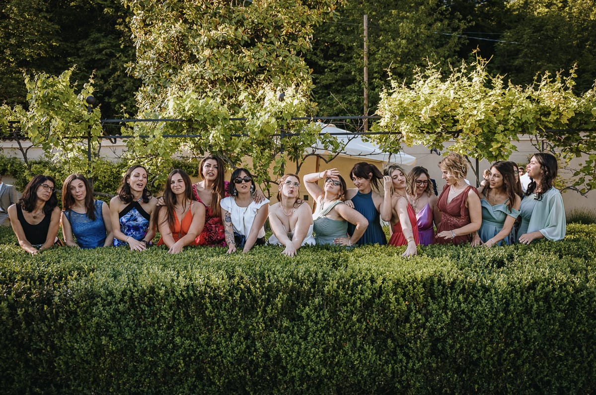Fotografo matrimonio Torino. Sposa con le amiche nel giardino all'italiana di Villa Ala. le ragazze hanno espressioni buffe.