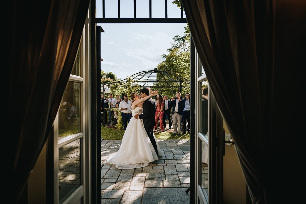Fotografo matrimonio Torino. Ballo degli sposi nel patio di Villa Ala. Gli sposi sono abbracciati davanti agli invitati che guardano.