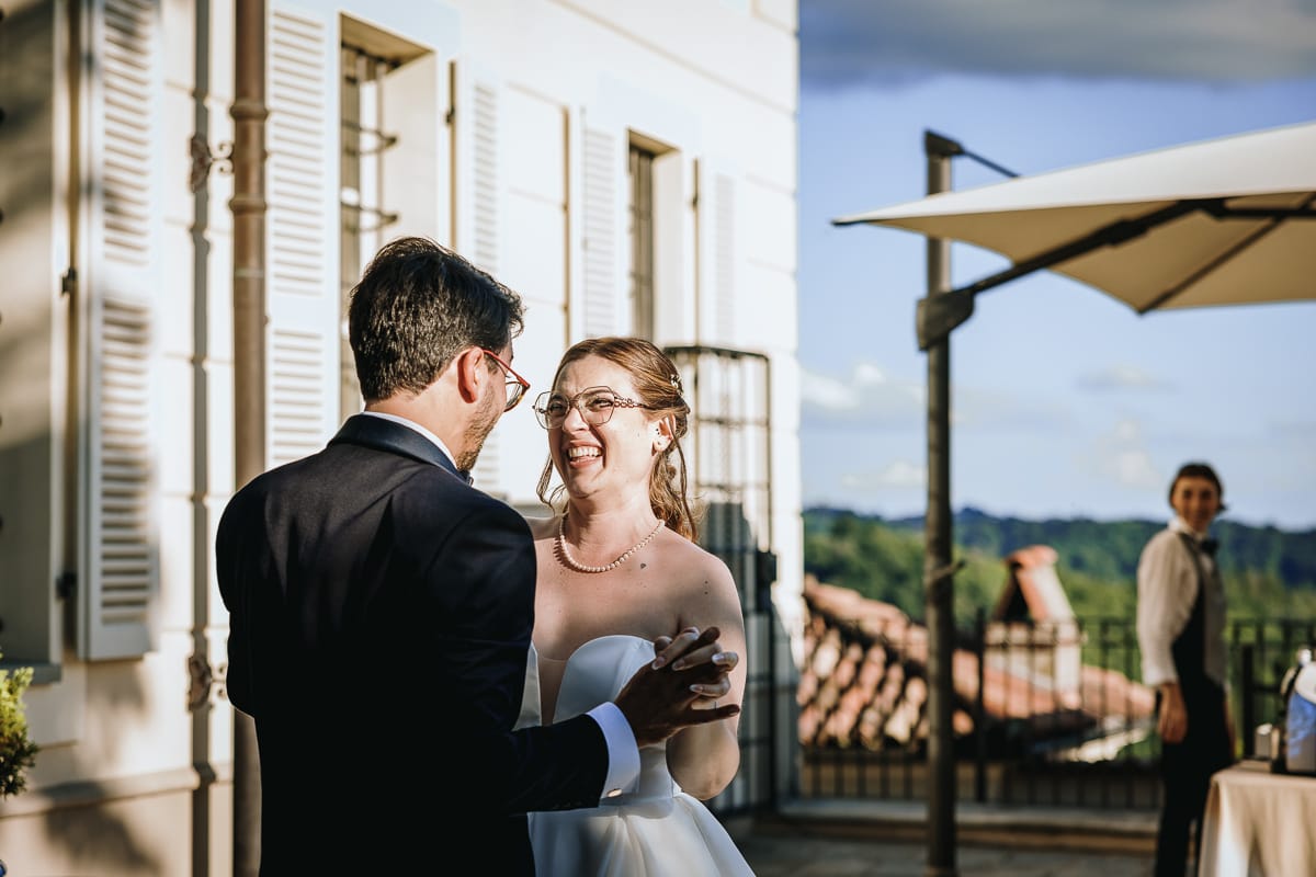 Fotografo matrimonio Torino. Ballo degli sposi nel patio di Villa Ala. Gli sposi si guardano sorridendo