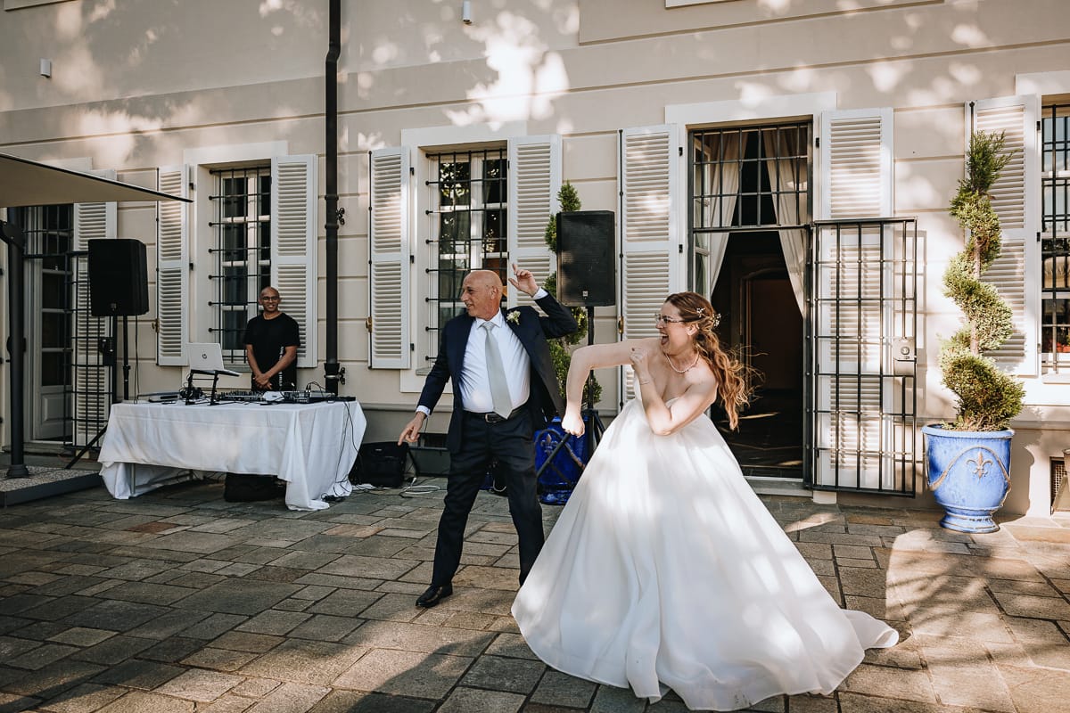 Fotografo matrimonio Torino. Ballo degli sposi con i genitori nel patio di Villa Ala. Sposa con il padre.