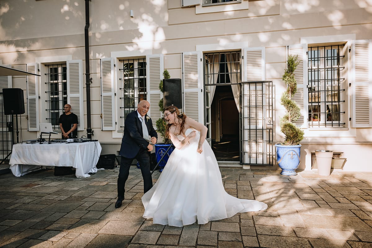 Fotografo matrimonio Torino. Ballo degli sposi con i genitori nel patio di Villa Ala. Sposa con il padre.