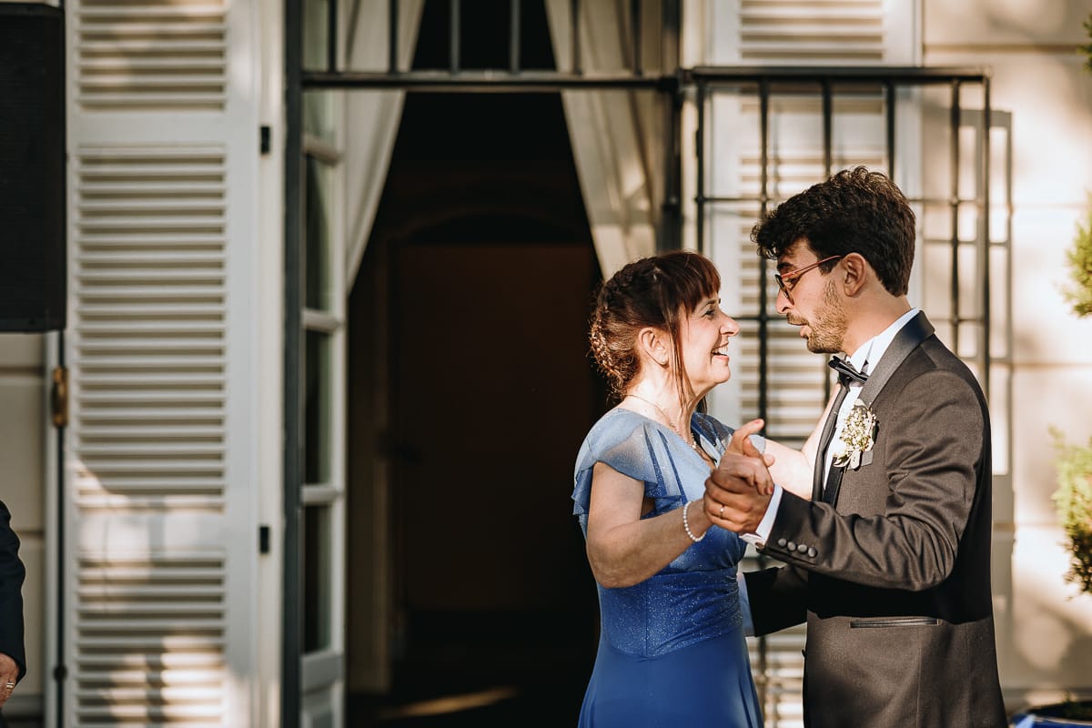 Fotografo matrimonio Torino. Ballo degli sposi con i genitori nel patio di Villa Ala. Sposo con la madre.