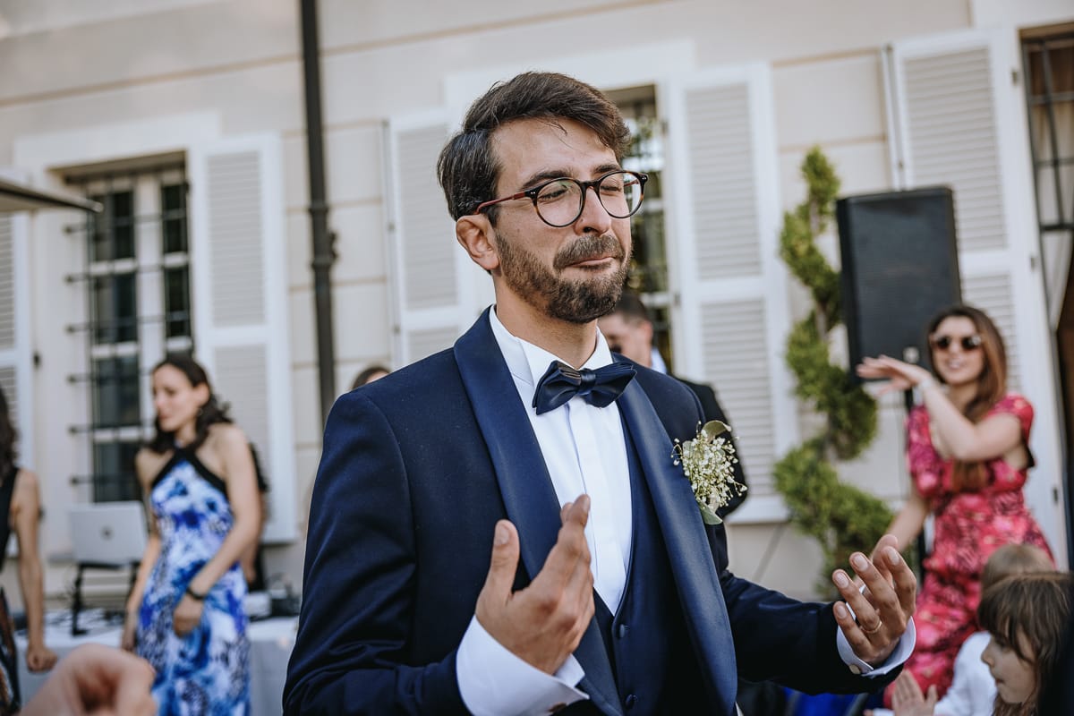 Fotografo matrimonio Torino. Ballo di gruppo nel patio di Villa Ala. sposo con un'espressione buffa.