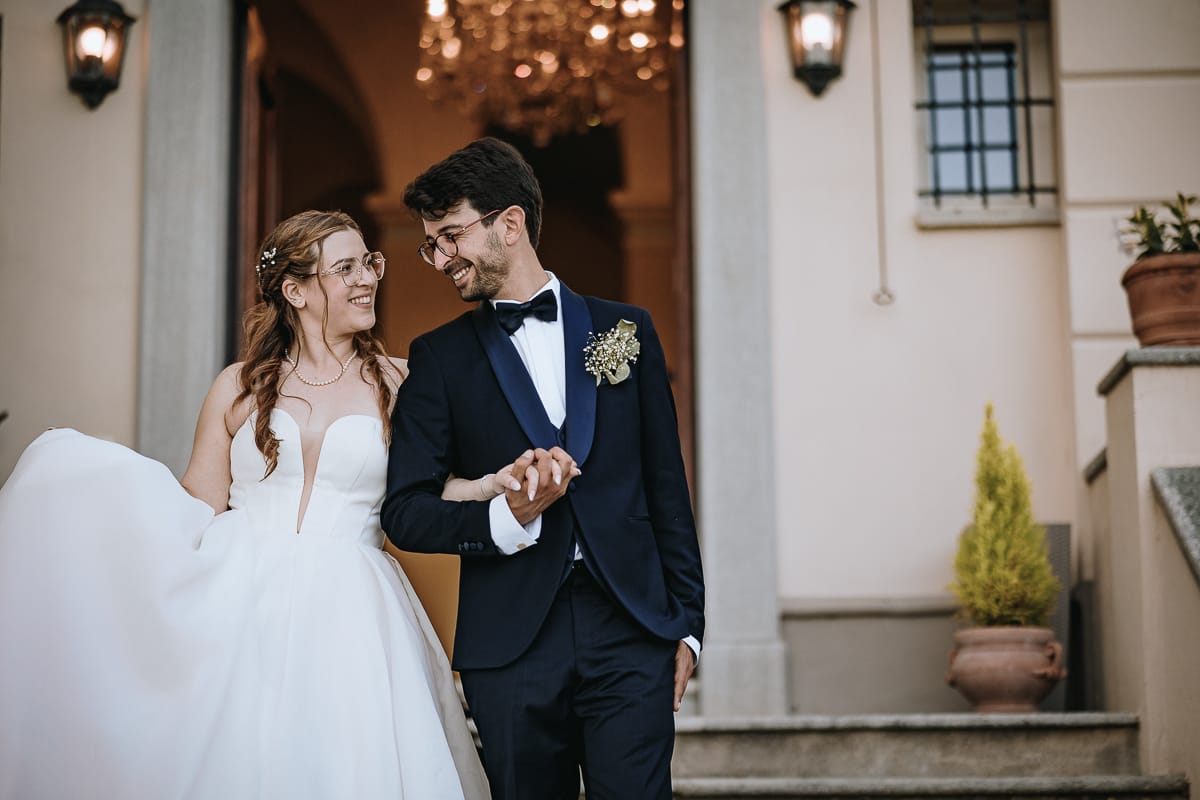 Fotografo matrimonio Torino. Gli sposi scendono le scale esterne di Villa Ala guardandosi teneramente.