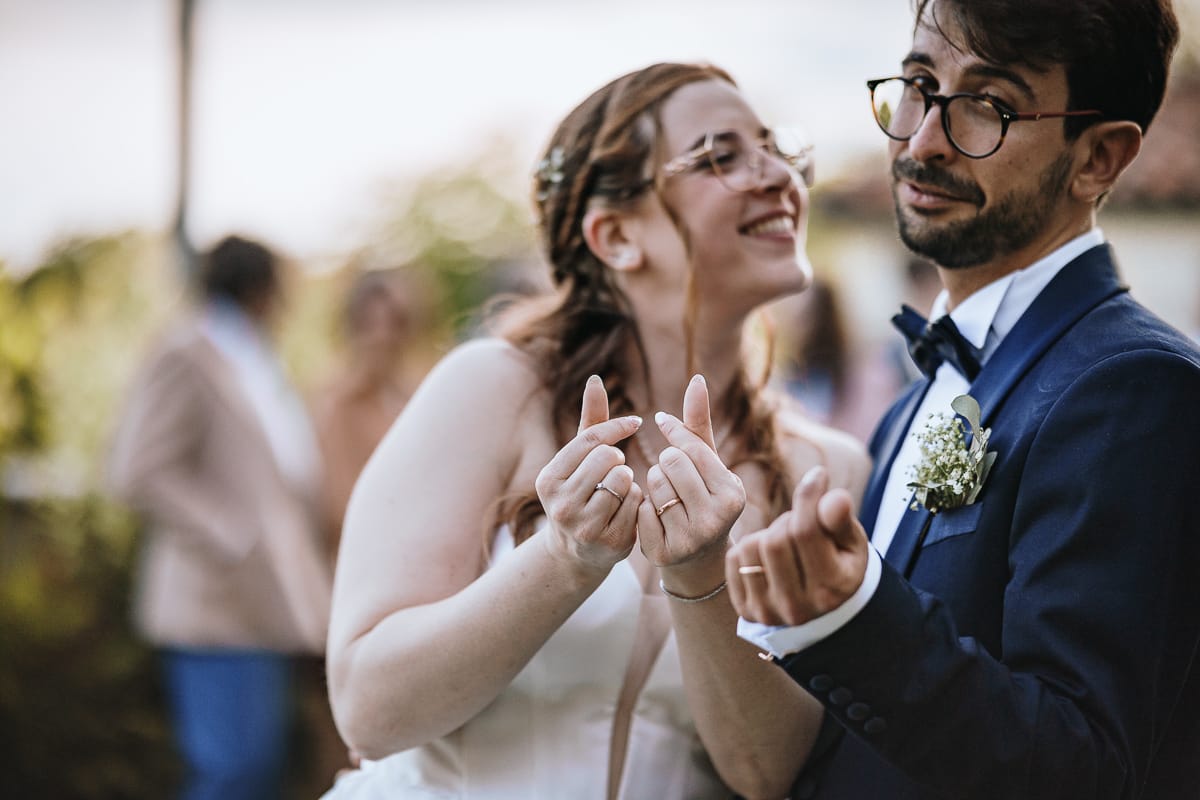 Fotografo matrimonio Torino. Sposi nella corte interna di Villa Ala. sposi fanno con le mani il gesto "wo ai ni" ti amo in cinese.