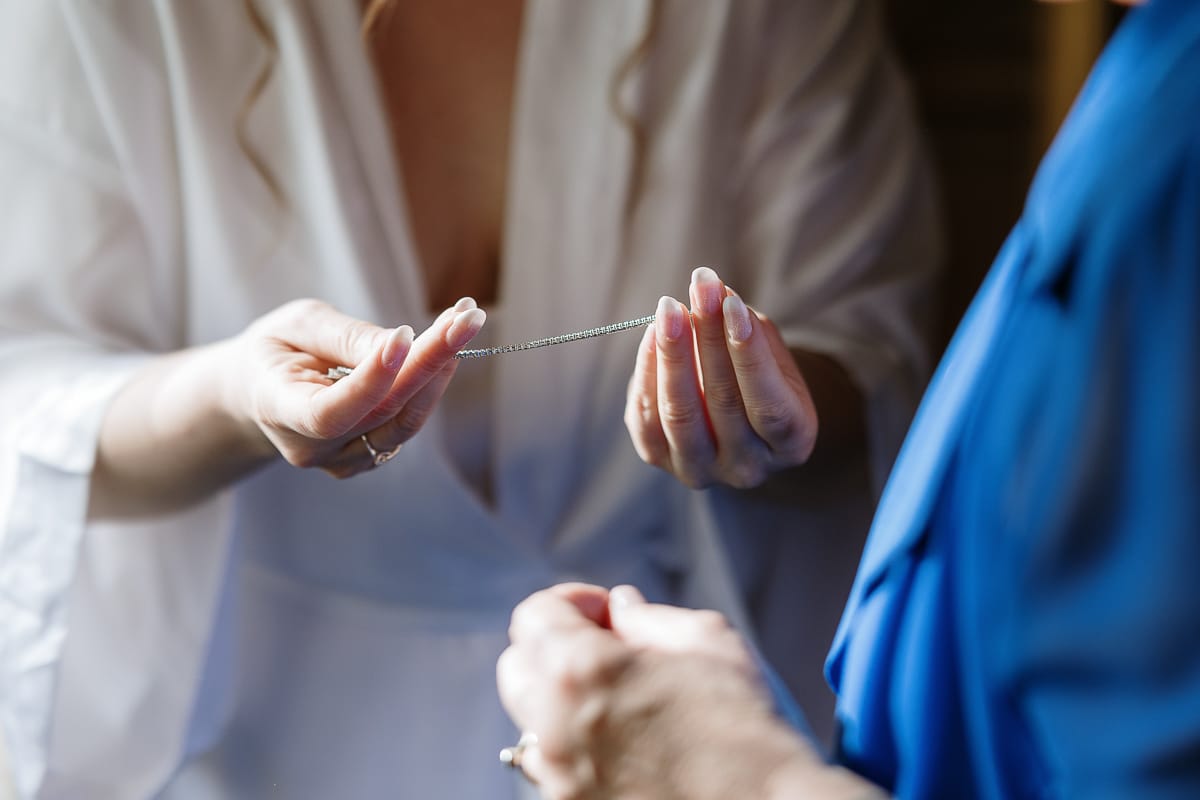 Preparazione della sposa a Madonna della Scala. Sposa sta per indossare il braccialetto