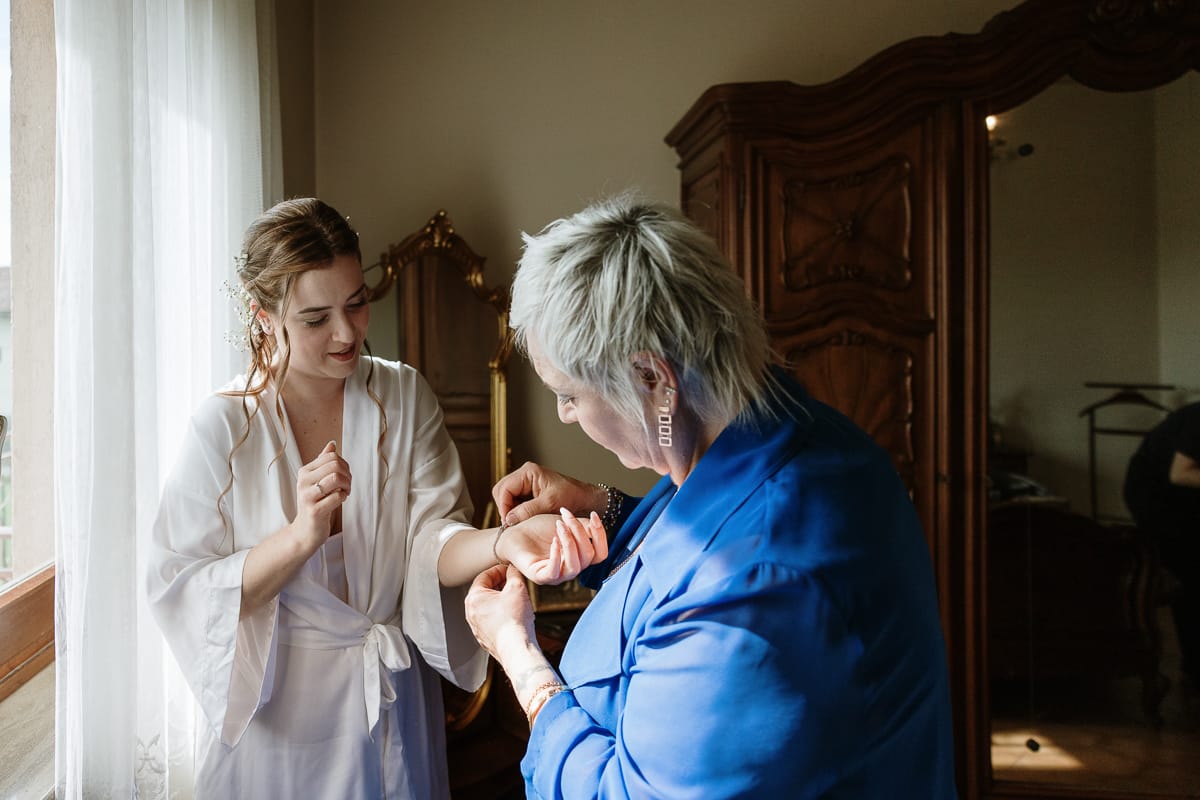 Preparazione della sposa a Madonna della Scala. Mamma aiuta la sposa ad indossare il braccialetto