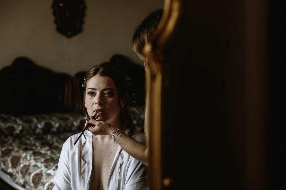 Preparazione della sposa a Madonna della Scala. Trucco delle labbra della sposa