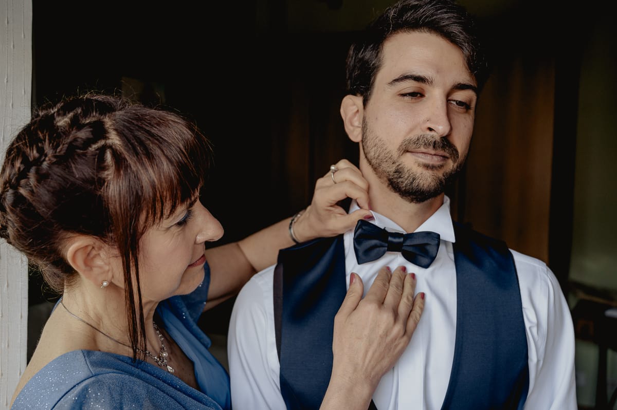 preparazione dello sposo a Chieri, mamma che sistema il papillon allo sposo