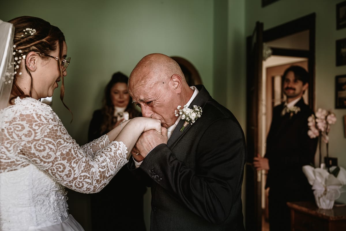 Preparazione della sposa a Madonna della Scala. Il papà bacia la mano alla sposa.