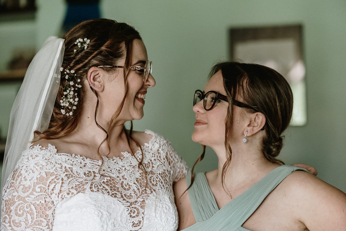 Preparazione della sposa a Madonna della Scala. La sposa sorride alla damigella d'onore.