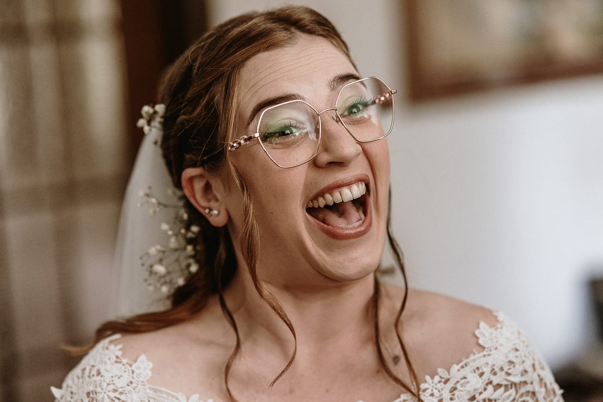 Preparazione della sposa a Madonna della Scala. Sposa felice che ride.