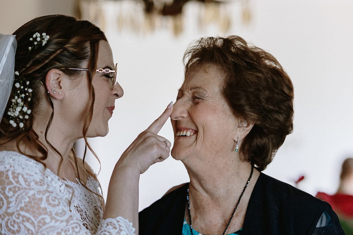 Preparazione della sposa a Madonna della Scala. Sposa accarezza la punta del naso della nonna.