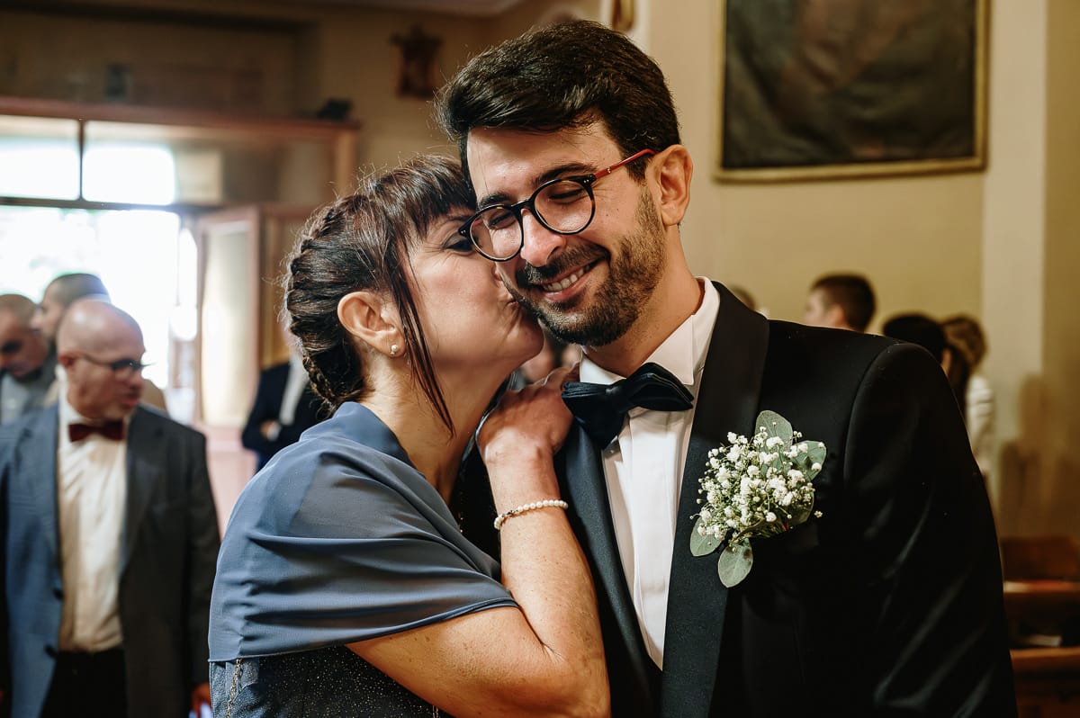 Cerimonia nella chiesa di Madonna della Scala. mamma bacia lo sposo.