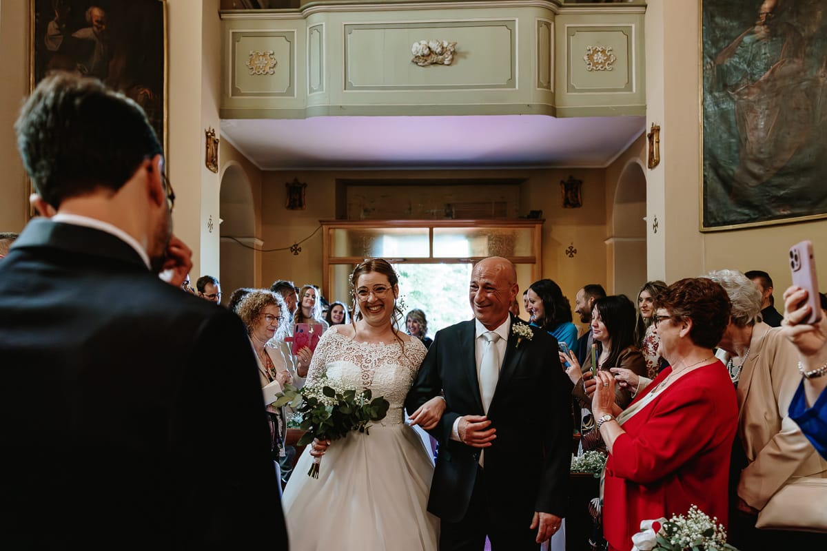 Cerimonia nella chiesa di Madonna della Scala. Entrata della sposa con il padre. la sposa sorride allo sposo che aspetta.