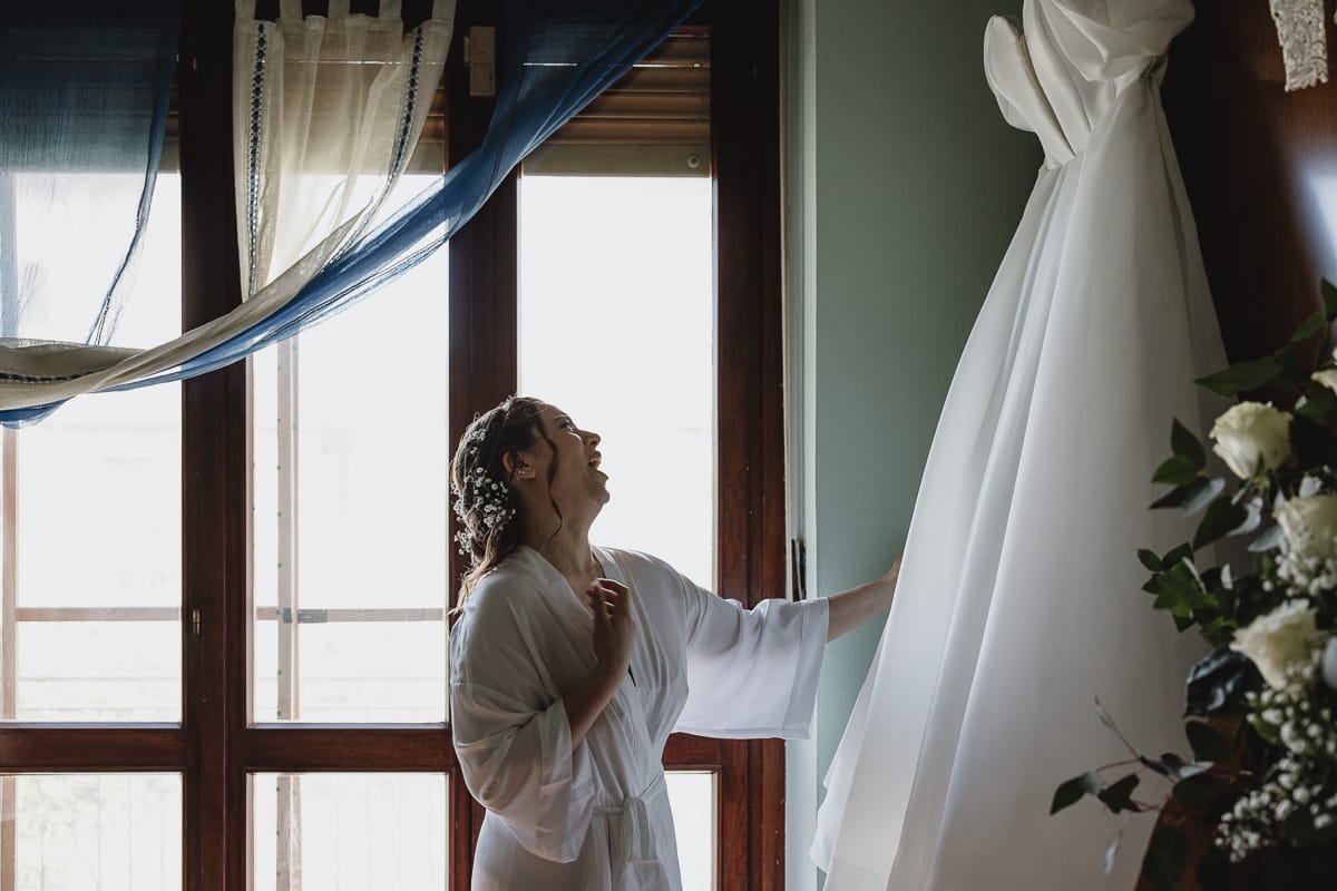 Fotografo matrimonio Torino preparazione sposa sposa guarda il suo abito