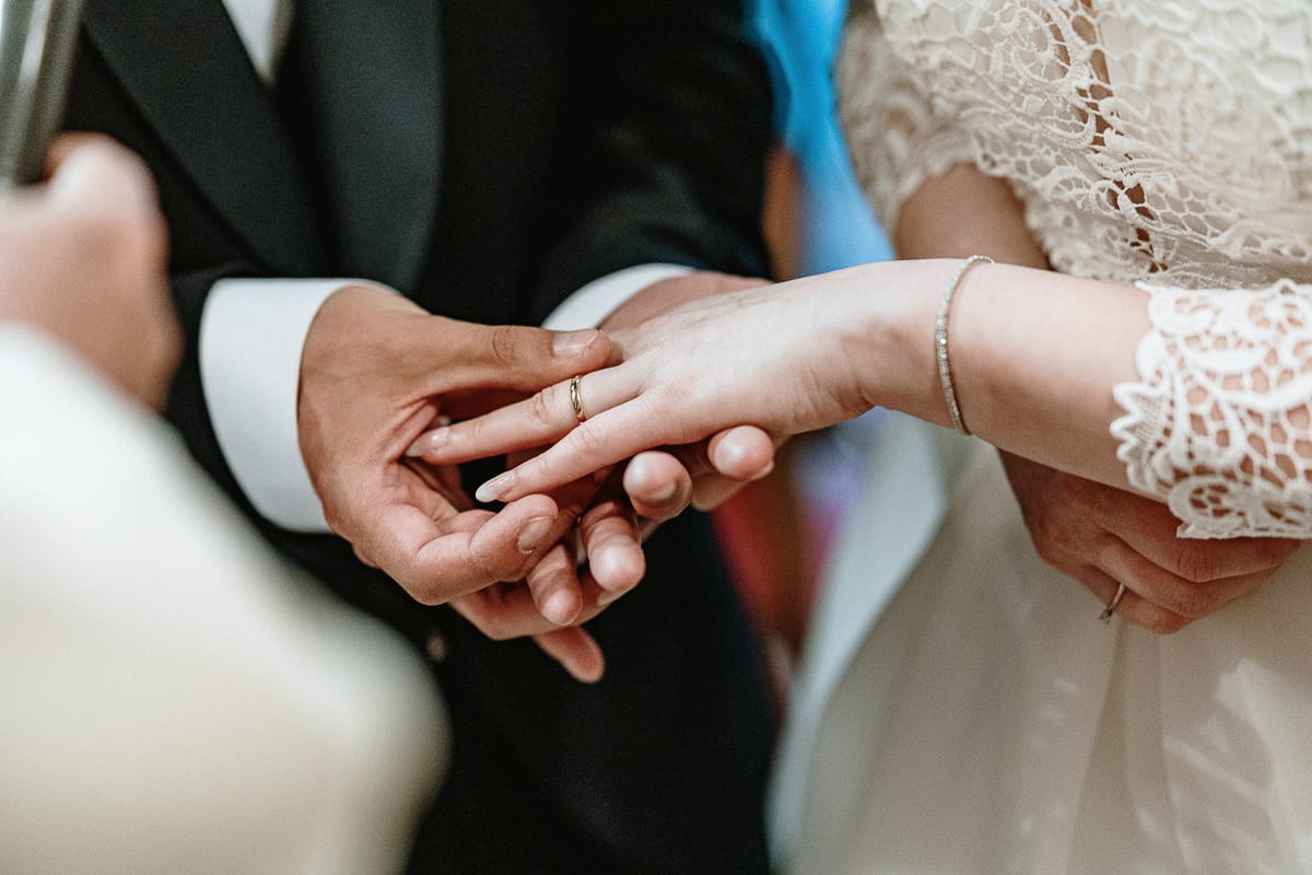 Cerimonia nella chiesa di Madonna della Scala. Sposo infila l'anello all'anulare della sposa.