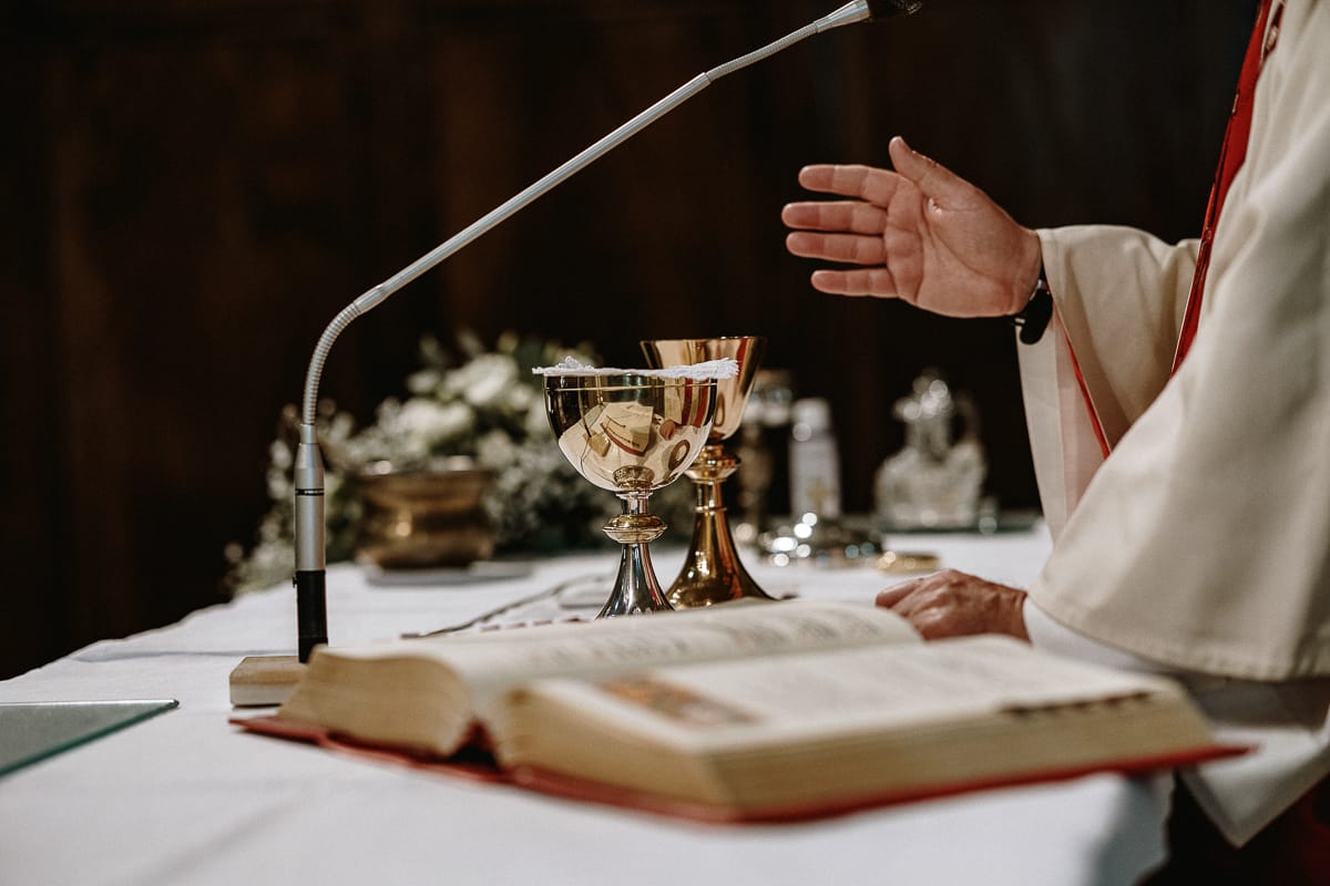 Cerimonia nella chiesa di Madonna della Scala.Il prete benedice le ostie e il calice.