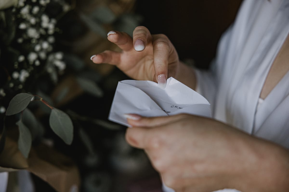 Preparazione della sposa a Madonna della Scala. Sposa legge il biglietto che accompagna le rose dello sposo