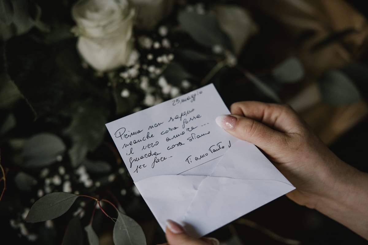 Preparazione della sposa a Madonna della Scala. Sposa legge il biglietto che accompagna le rose dello sposo