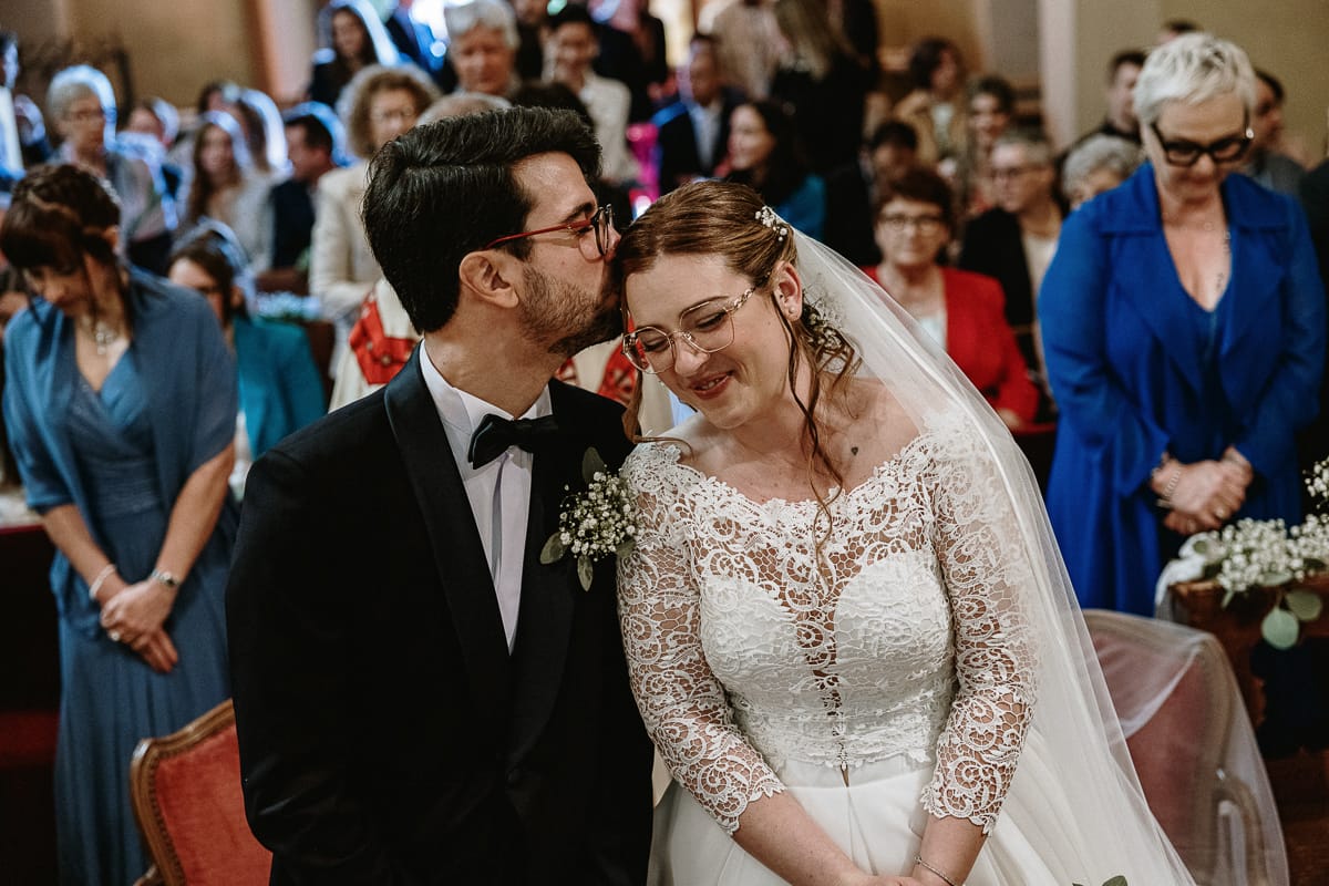 Cerimonia nella chiesa di Madonna della Scala. Lo sposo bacia la sposa sulla testa.