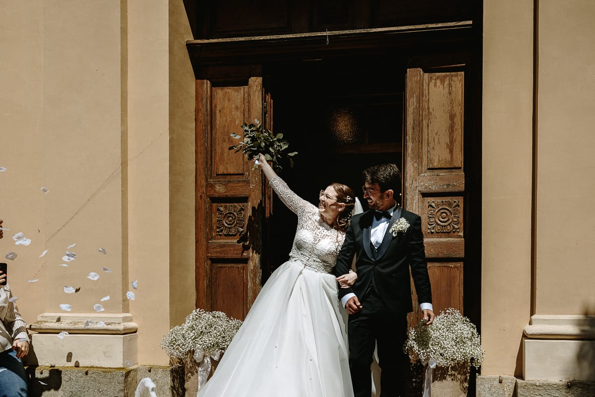 Cerimonia nella chiesa di Madonna della Scala.Uscita degli sposi. La sposa alza il bouquet verso il cielo.