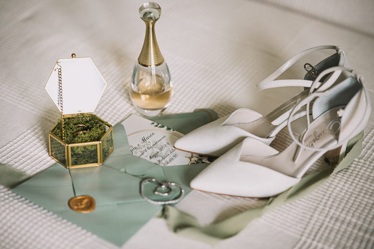 Preparazione della sposa a Madonna della Scala. Accessori della sposa, scarpe, anelli, profumo, orecchini,braccialetto e partecipazione.