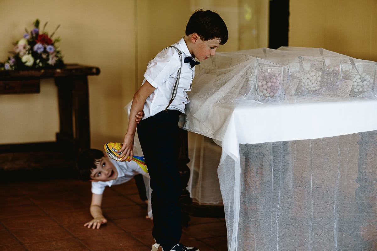 Fotografo matrimonio in Monferrato. Matrimonio di Serena e Fabrizio al Vecchio Castagno di Cocconato d'Asti. Aperitivo. Bambini francesi guardano incuriositi i confetti.