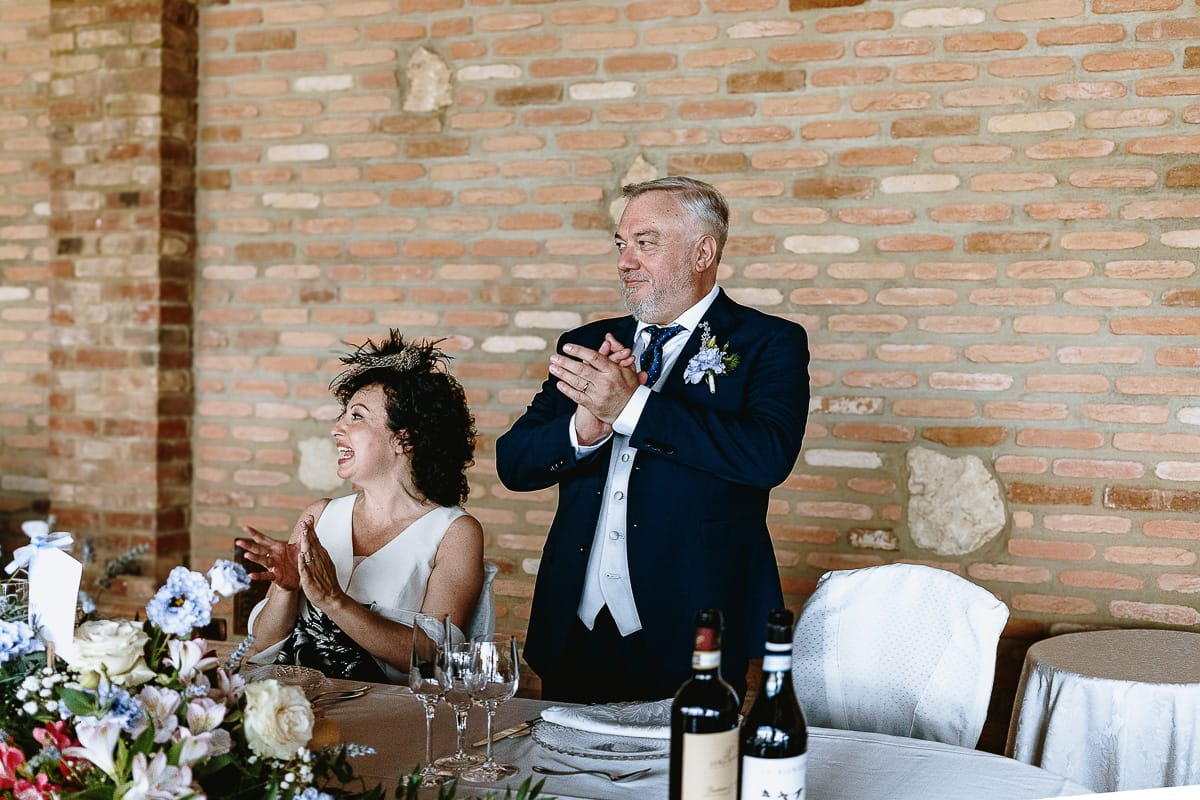 Fotografo matrimonio in Monferrato. Matrimonio di Serena e Fabrizio al Vecchio Castagno di Cocconato d'Asti. Pranzo nuziale. Sposi applaudono.