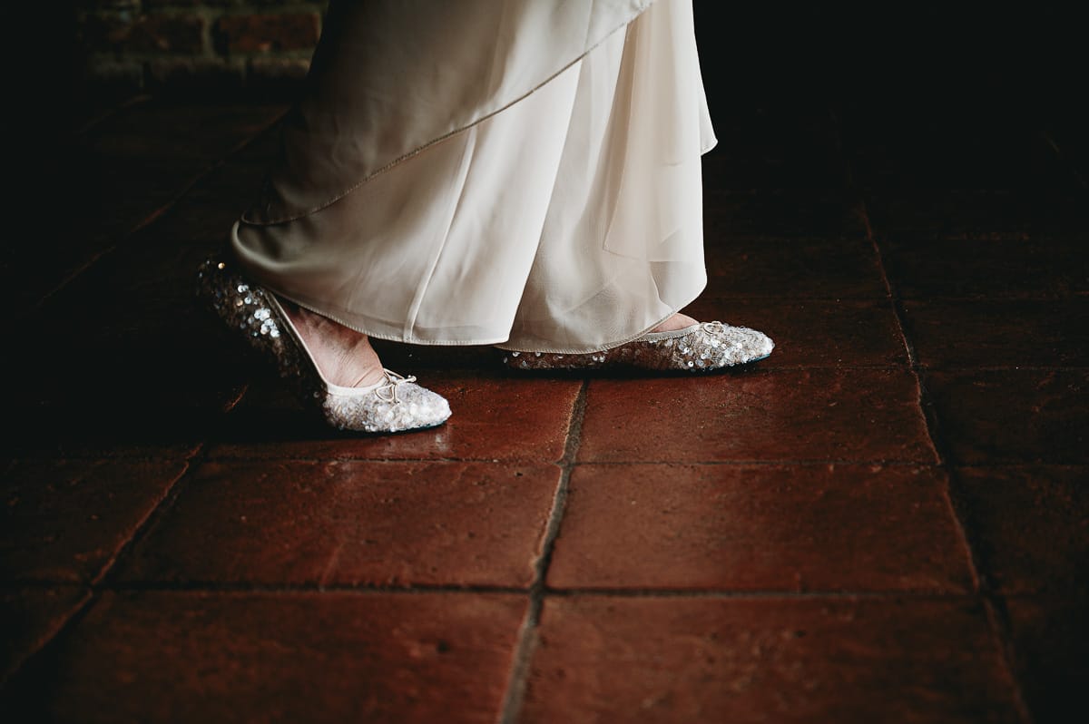 Fotografo matrimonio in Monferrato. Matrimonio di Serena e Fabrizio al Vecchio Castagno di Cocconato d'Asti. Sposa ha cambiato le scarpe. ha un paio di ballerine.