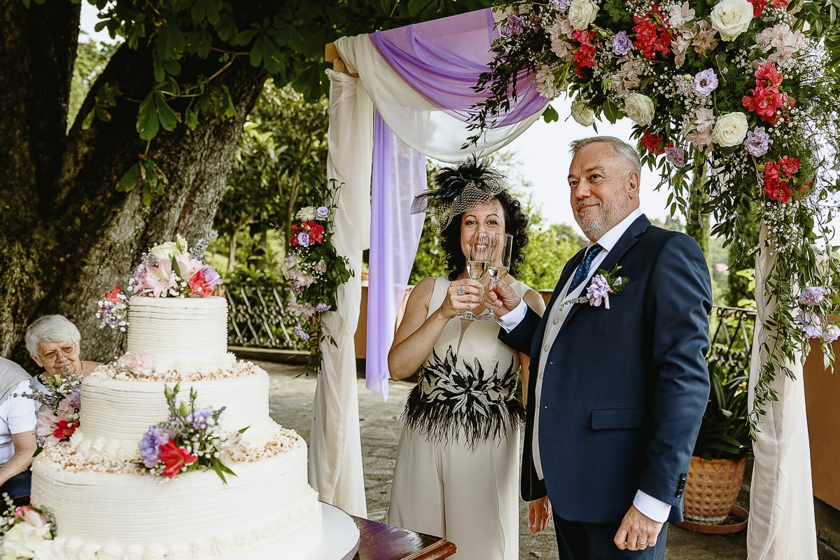 Fotografo matrimonio in Monferrato. Matrimonio di Serena e Fabrizio al Vecchio Castagno di Cocconato d'Asti. Taglio della torta. sposi brindano.