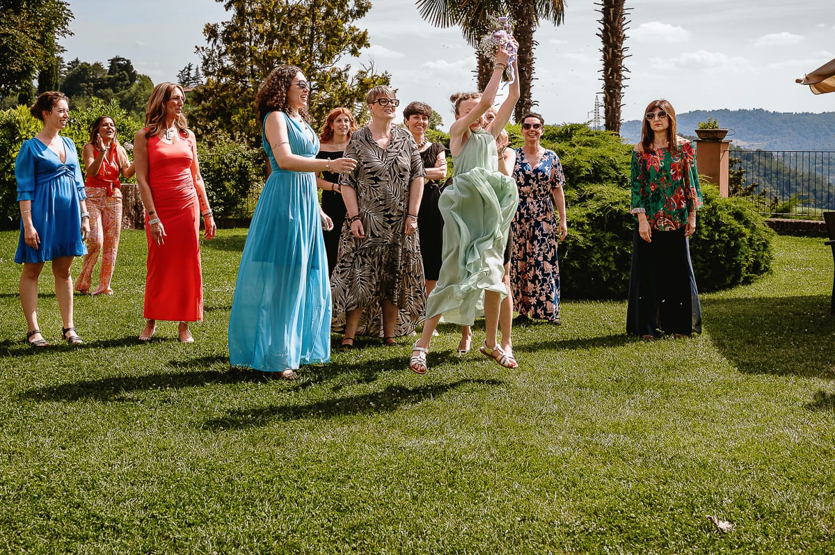 Fotografo matrimonio in Monferrato. Matrimonio di Serena e Fabrizio al Vecchio Castagno di Cocconato d'Asti. Lancio del bouquet.Primo lancio non valido. Il bouquet lo prende al volo la nipotina troppo giovane.