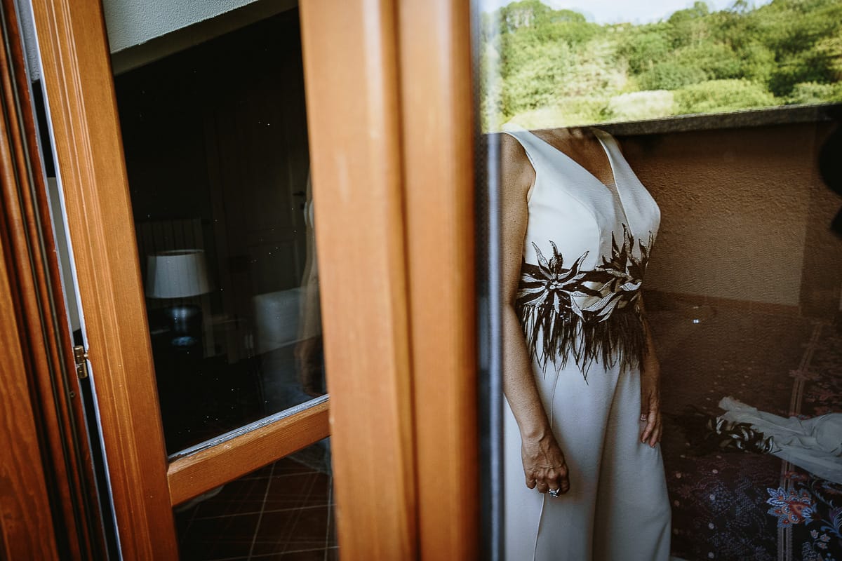 Fotografo matrimonio in Monferrato. Matrimonio di Serena e Fabrizio. Preparazione a Baldissero Torinese. Sposa riflessa nella porta a vetri.