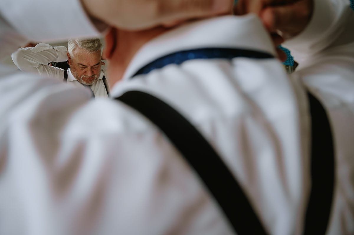 Fotografo matrimonio in Monferrato. Matrimonio di Serena e Fabrizio. Preparazione a Baldissero Torinese. Sposo allo specchio si sistema la cravatta.