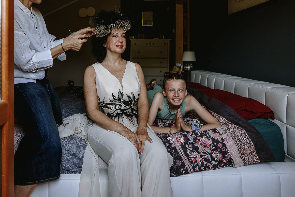 Fotografo matrimonio in Monferrato. Matrimonio di Serena e Fabrizio. Preparazione a Baldissero Torinese. Parrucchiera mette il cerchietto con la veletta alla sposa.