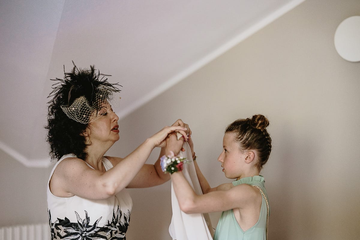Fotografo matrimonio in Monferrato. Matrimonio di Serena e Fabrizio. Preparazione a Baldissero Torinese. Nipotina aiuta la sposa ad indossare la mantellina.