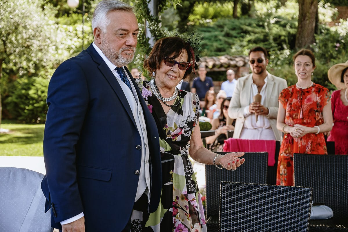 Fotografo matrimonio in Monferrato. Matrimonio di Serena e Fabrizio al Vecchio Castagno di Cocconato d'Asti.Sposo si dirige verso la zona della cerimonia al braccio della suocera.